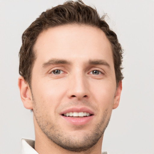 Joyful white young-adult male with short  brown hair and grey eyes