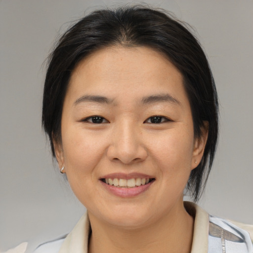 Joyful asian young-adult female with medium  brown hair and brown eyes