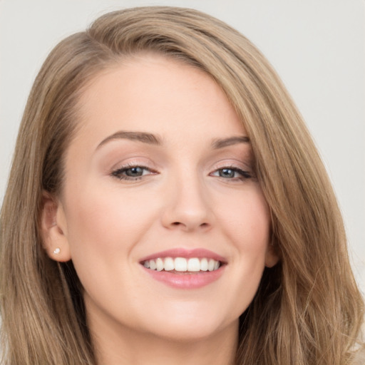 Joyful white young-adult female with long  brown hair and grey eyes