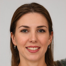 Joyful white young-adult female with long  brown hair and grey eyes