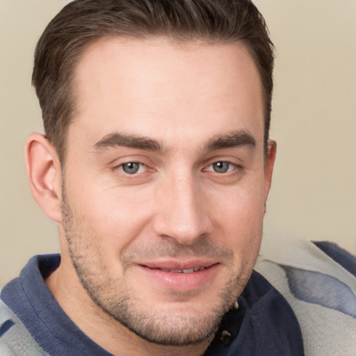 Joyful white young-adult male with short  brown hair and grey eyes