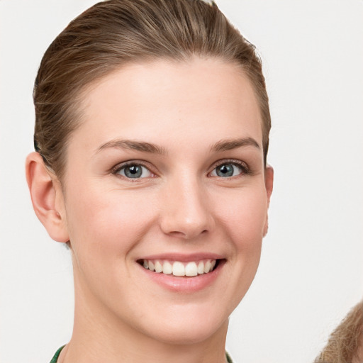 Joyful white young-adult female with short  brown hair and grey eyes