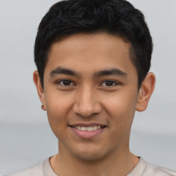 Joyful latino young-adult male with short  brown hair and brown eyes