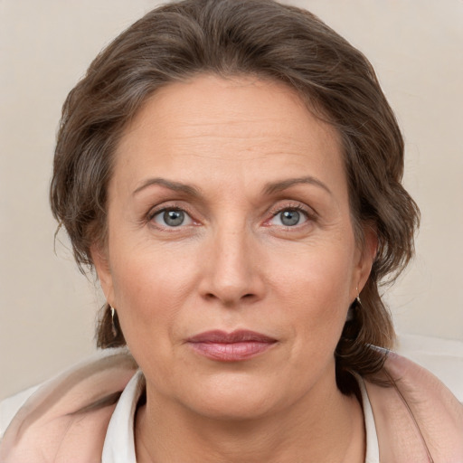 Joyful white adult female with medium  brown hair and grey eyes