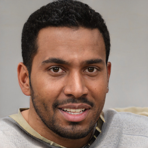 Joyful black young-adult male with short  brown hair and brown eyes