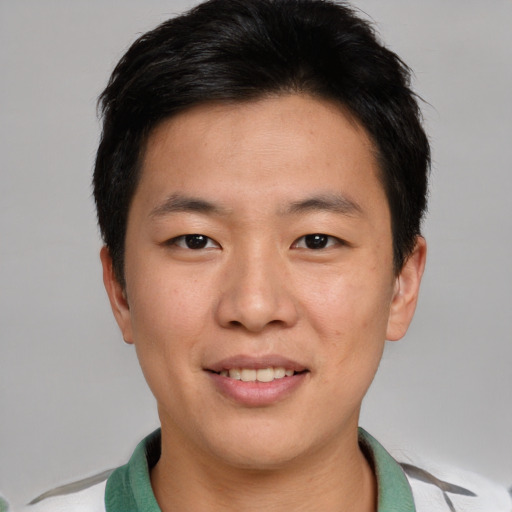 Joyful asian young-adult male with short  brown hair and brown eyes