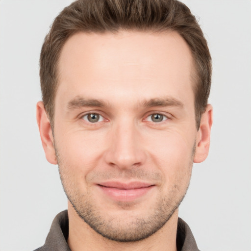 Joyful white young-adult male with short  brown hair and grey eyes