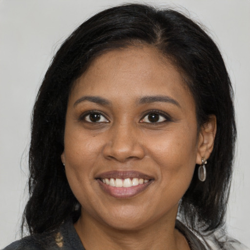 Joyful black young-adult female with medium  brown hair and brown eyes