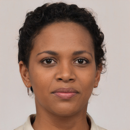 Joyful black young-adult female with short  brown hair and brown eyes