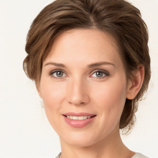 Joyful white young-adult female with medium  brown hair and green eyes