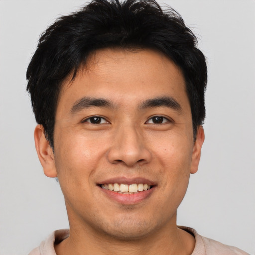 Joyful asian young-adult male with short  black hair and brown eyes