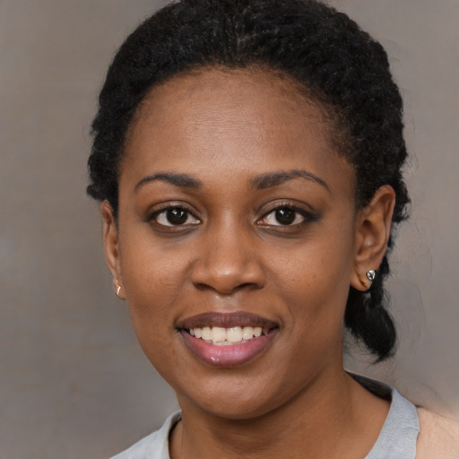 Joyful black young-adult female with short  black hair and brown eyes