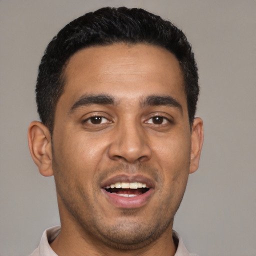 Joyful black young-adult male with short  black hair and brown eyes