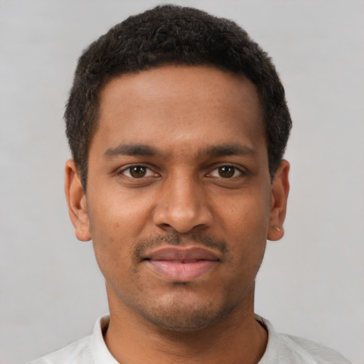 Joyful black young-adult male with short  brown hair and brown eyes