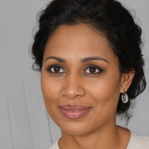 Joyful black young-adult female with medium  brown hair and brown eyes