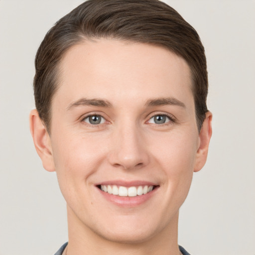 Joyful white young-adult female with short  brown hair and grey eyes