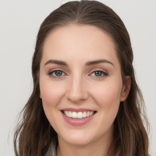 Joyful white young-adult female with long  brown hair and grey eyes