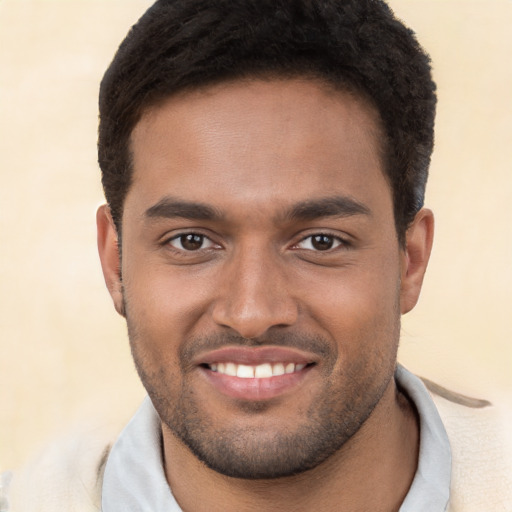 Joyful black young-adult male with short  brown hair and brown eyes