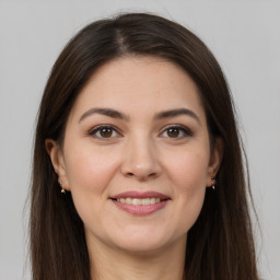 Joyful white young-adult female with long  brown hair and brown eyes