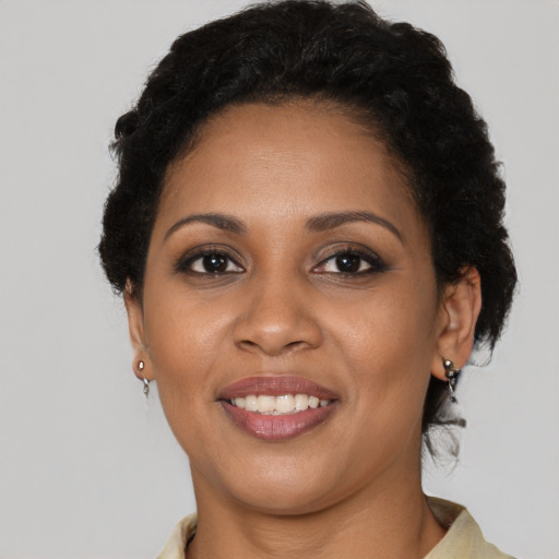 Joyful black young-adult female with short  black hair and brown eyes