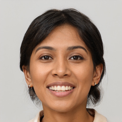 Joyful latino young-adult female with medium  brown hair and brown eyes