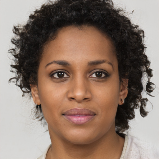 Joyful black young-adult female with short  brown hair and brown eyes