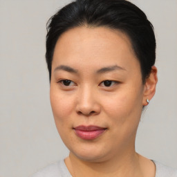 Joyful asian young-adult female with short  black hair and brown eyes