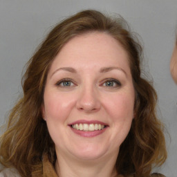 Joyful white adult female with long  brown hair and green eyes