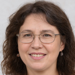 Joyful white adult female with long  brown hair and grey eyes