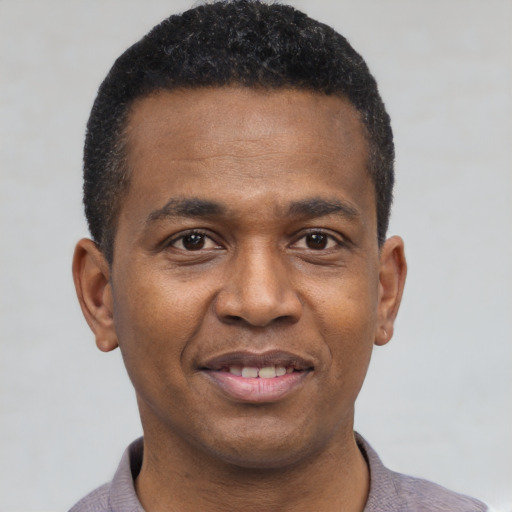 Joyful black young-adult male with short  brown hair and brown eyes