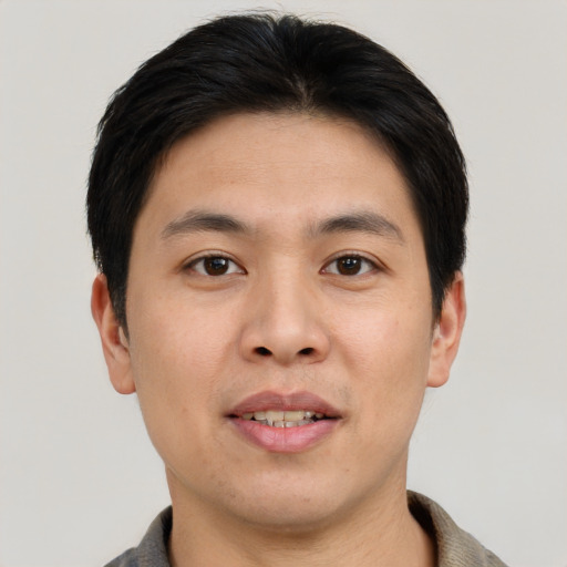 Joyful asian young-adult male with short  brown hair and brown eyes
