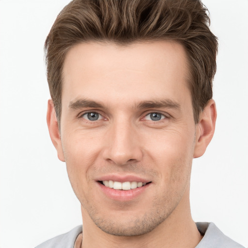 Joyful white young-adult male with short  brown hair and grey eyes