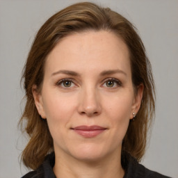 Joyful white adult female with medium  brown hair and grey eyes