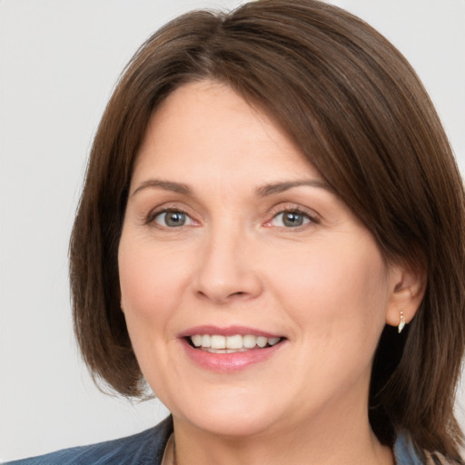 Joyful white adult female with medium  brown hair and grey eyes