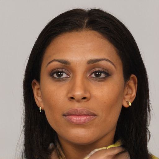 Joyful black young-adult female with long  brown hair and brown eyes