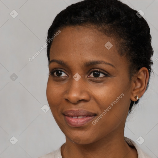 Joyful black young-adult female with short  black hair and brown eyes