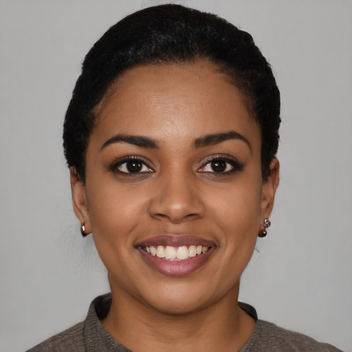 Joyful black young-adult female with short  black hair and brown eyes
