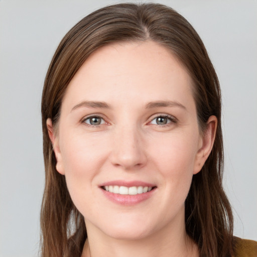 Joyful white young-adult female with long  brown hair and grey eyes