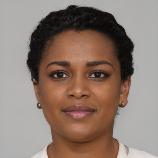 Joyful black young-adult female with short  black hair and brown eyes