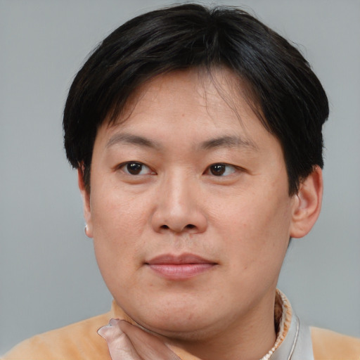Joyful asian adult male with short  brown hair and brown eyes