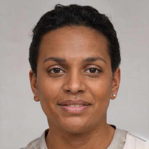 Joyful black young-adult female with short  brown hair and brown eyes