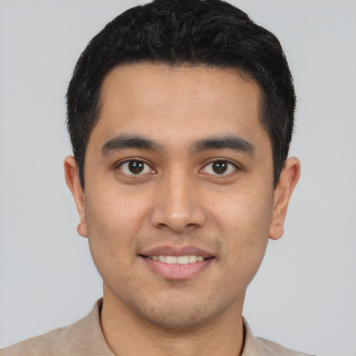 Joyful latino young-adult male with short  brown hair and brown eyes