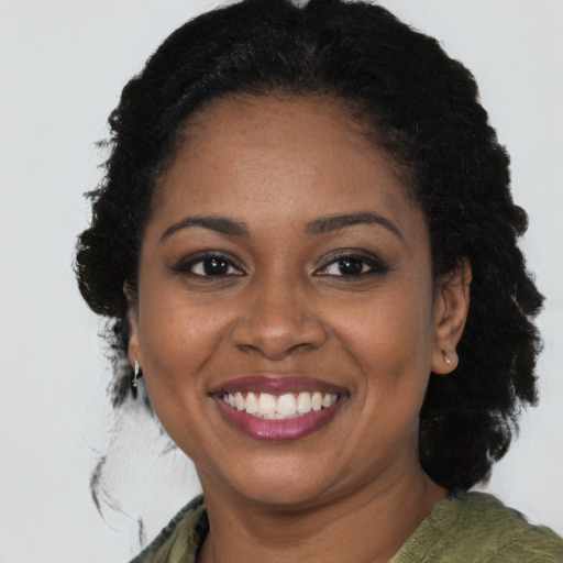 Joyful black young-adult female with medium  brown hair and brown eyes