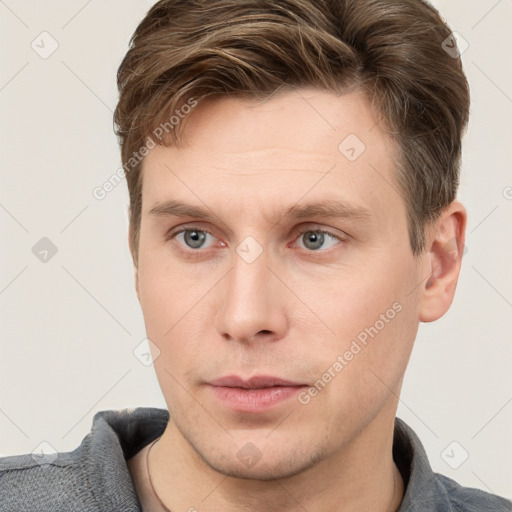 Joyful white young-adult male with short  brown hair and grey eyes