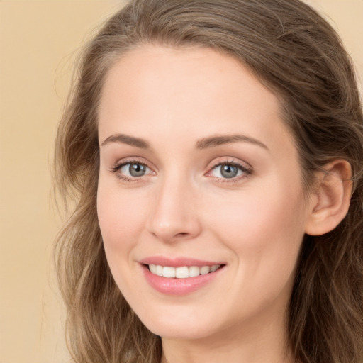 Joyful white young-adult female with long  brown hair and green eyes