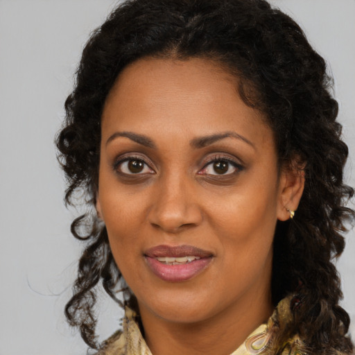 Joyful black young-adult female with medium  brown hair and brown eyes