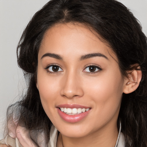 Joyful latino young-adult female with long  brown hair and brown eyes