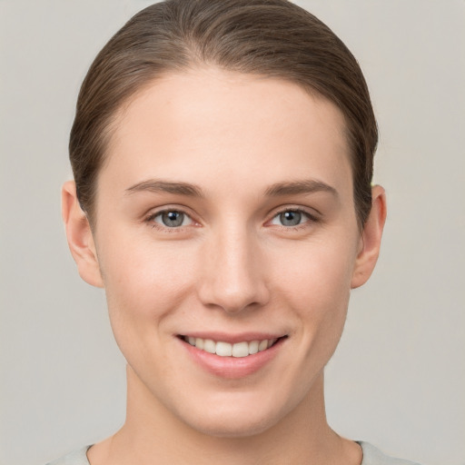 Joyful white young-adult female with short  brown hair and grey eyes