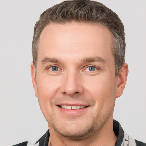 Joyful white young-adult male with short  brown hair and grey eyes