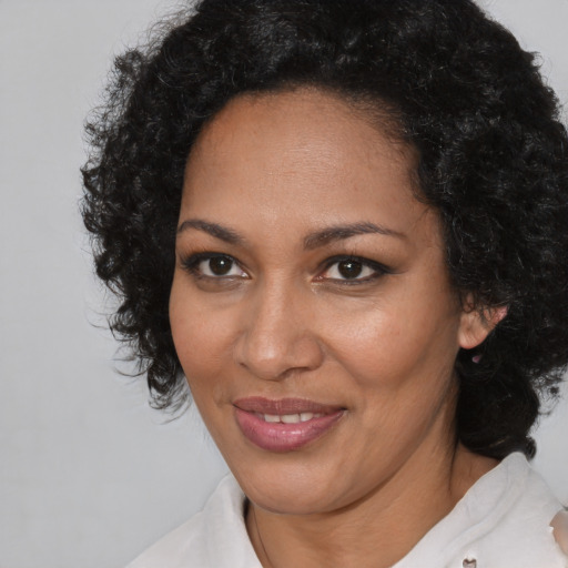 Joyful black adult female with medium  brown hair and brown eyes